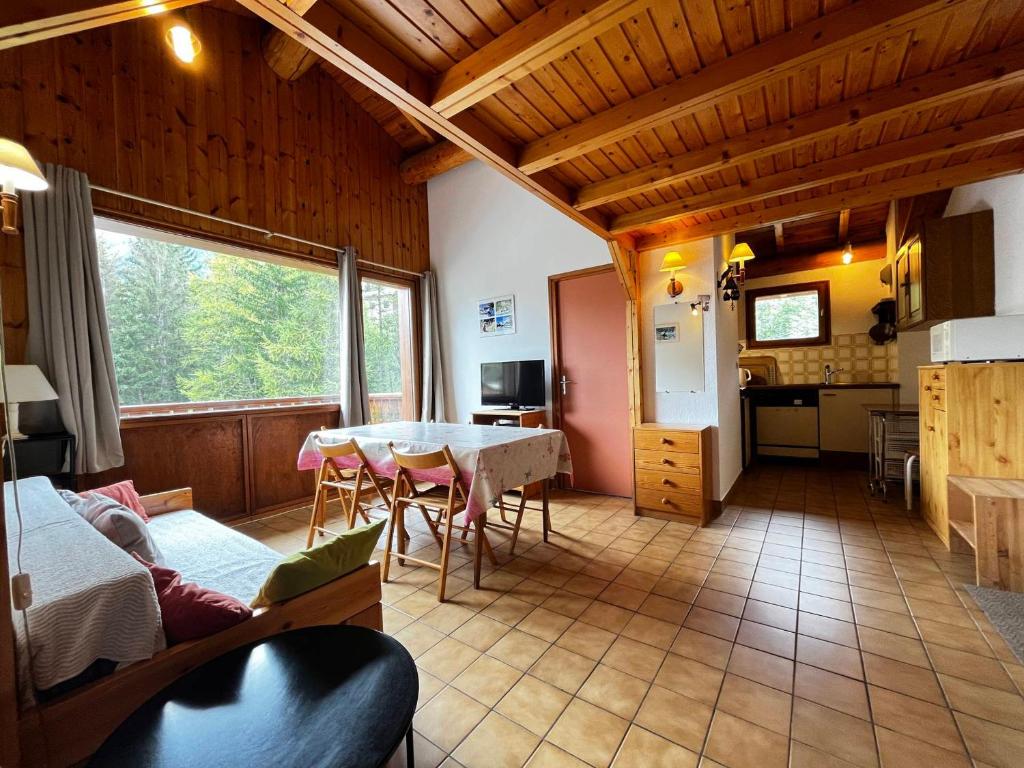 a living room with a table and a kitchen at Appartement Lanslevillard, 3 pièces, 4 personnes - FR-1-508-296 in Lanslebourg-Mont-Cenis