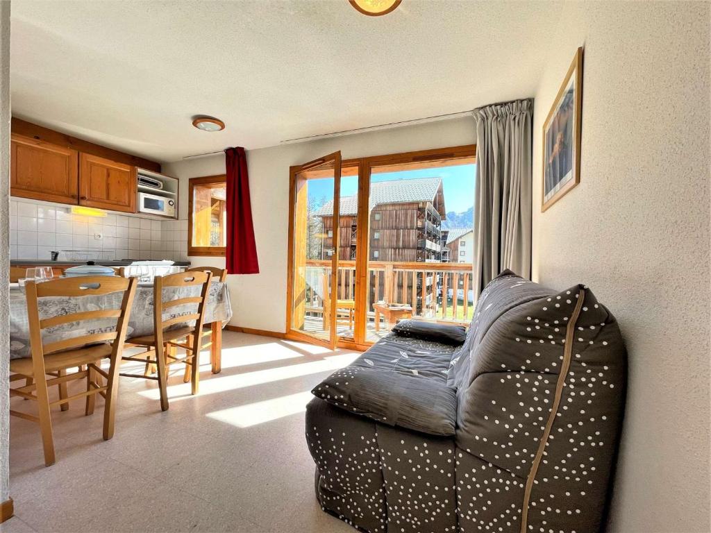 un salon avec un canapé et une table et une cuisine dans l'établissement Appartement 2 pièces, 6 pers, animaux admis, parking, près des pistes - FR-1-525-281, à Saint-Étienne-en-Dévoluy