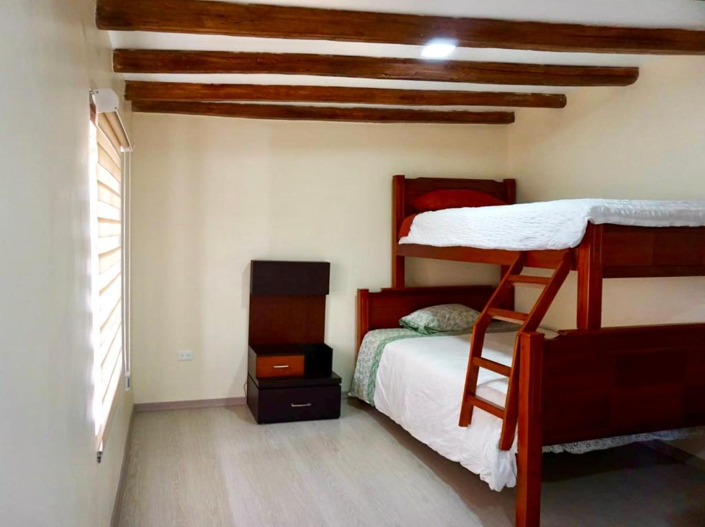 um quarto com 2 beliches e uma janela em Virgi Hostel em Quito
