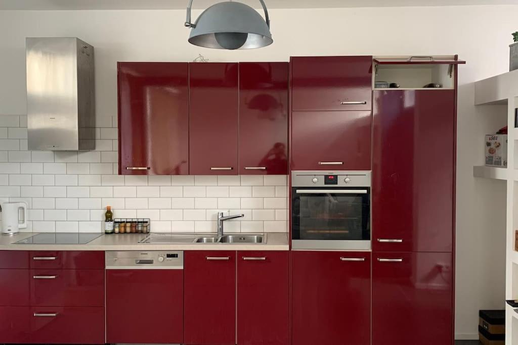 uma cozinha com armários vermelhos e um lavatório em Peaceful House & Garden (20min EU & City Center) em Bruxelas