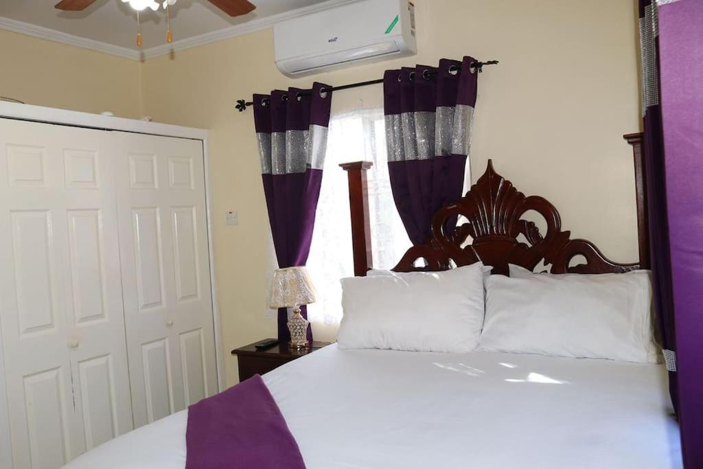 a bedroom with a large bed with purple curtains at The Royal View (Fully AC) in Banbury