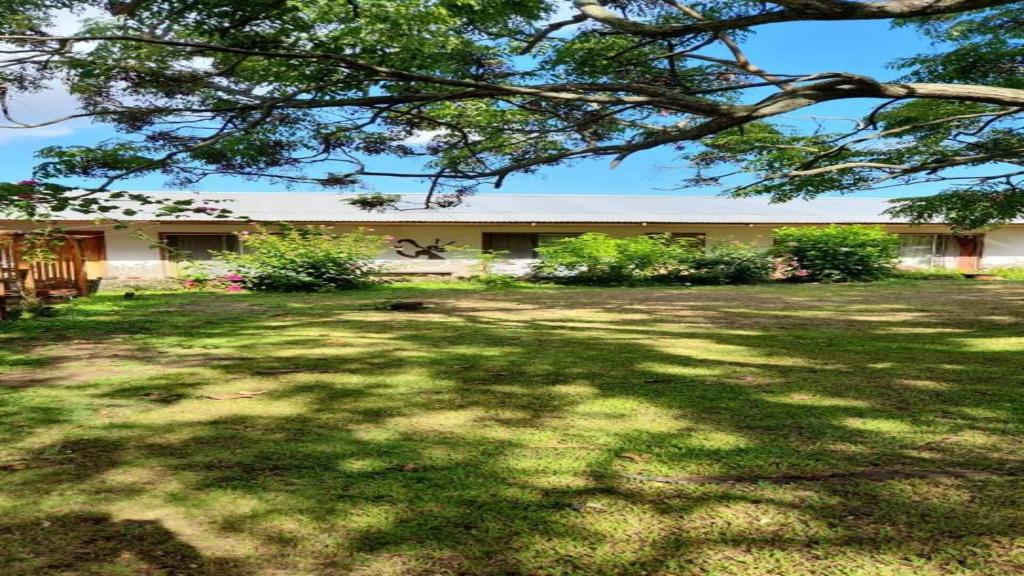 a large yard with a building in the background at Hostal Harepakoba in Hanga Roa