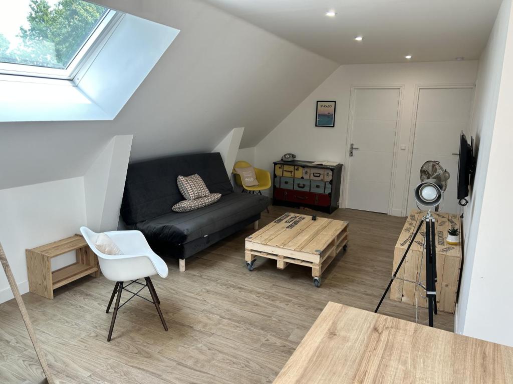 uma sala de estar com um sofá preto e uma mesa em Traou Mad - Gwenn Ha Du em Merlevenez