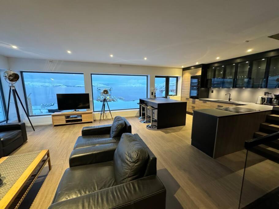 een grote woonkamer met een bank en een televisie bij Arctic Sea Breeze in Kirkenes