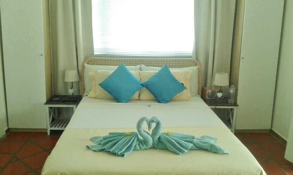 een bed met twee zwanen gemaakt van handdoeken bij Karibu Aruba Boutique Hotel in Palm-Eagle Beach