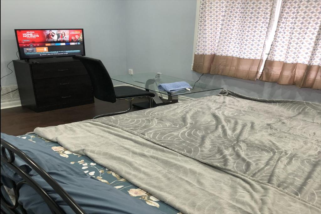 ShayCozyDelux-Room-101 في بيكرينغ: سرير في غرفة مع تلفزيون ومكتب