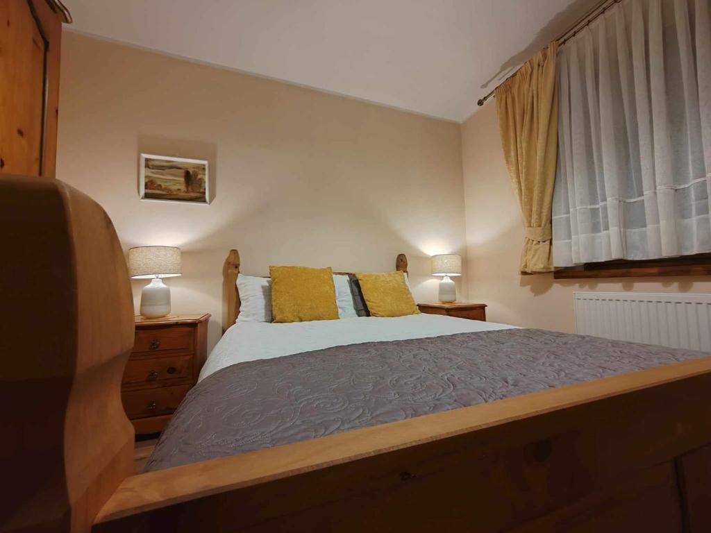 a bedroom with a bed with yellow pillows and a window at Akacja Apartament in Rzeszów