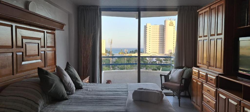 a hotel room with a bed and a large window at Departamento Tipo Estudio Dynasty Isla de Margarita in Porlamar