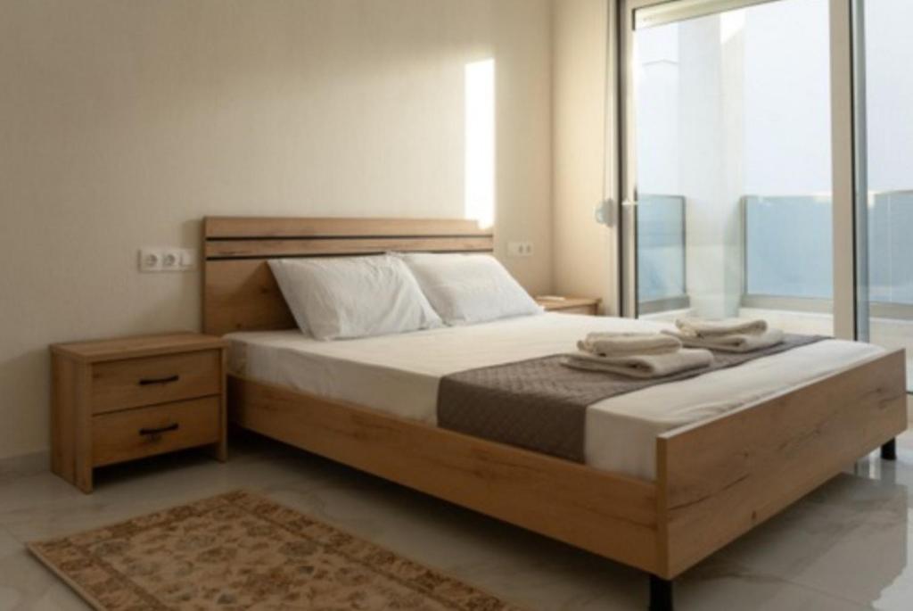 尼基季的住宿－安德烈亞斯複式小屋和公寓，一间卧室设有一张大床和一个窗户。