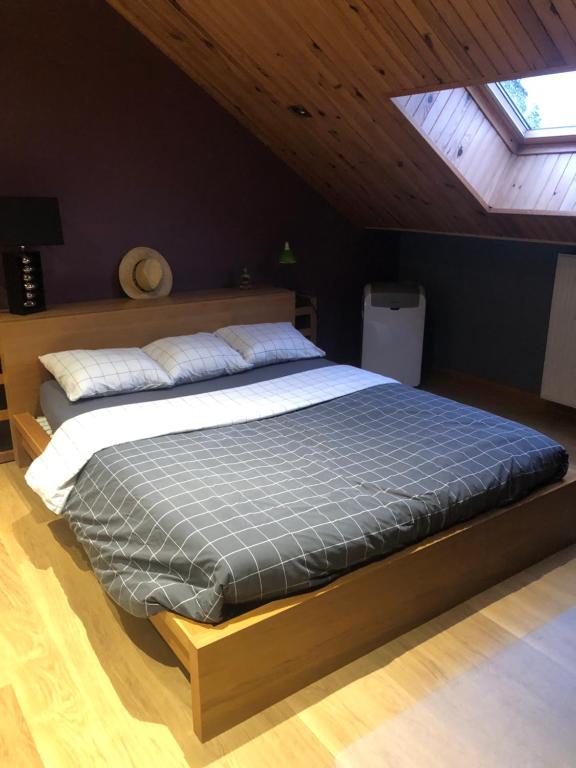 uma cama grande num quarto com tecto em Chambre d'hôtes le Vivaldi em Seraing