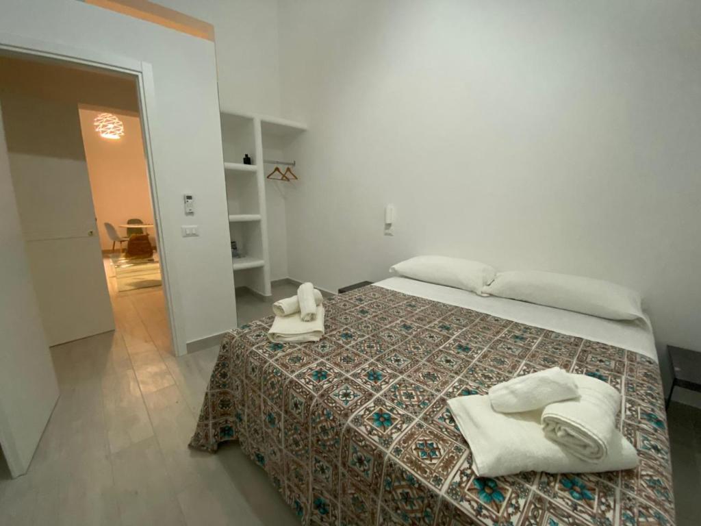 - une chambre avec un lit et des serviettes dans l'établissement VIA ROMA, à Trapani