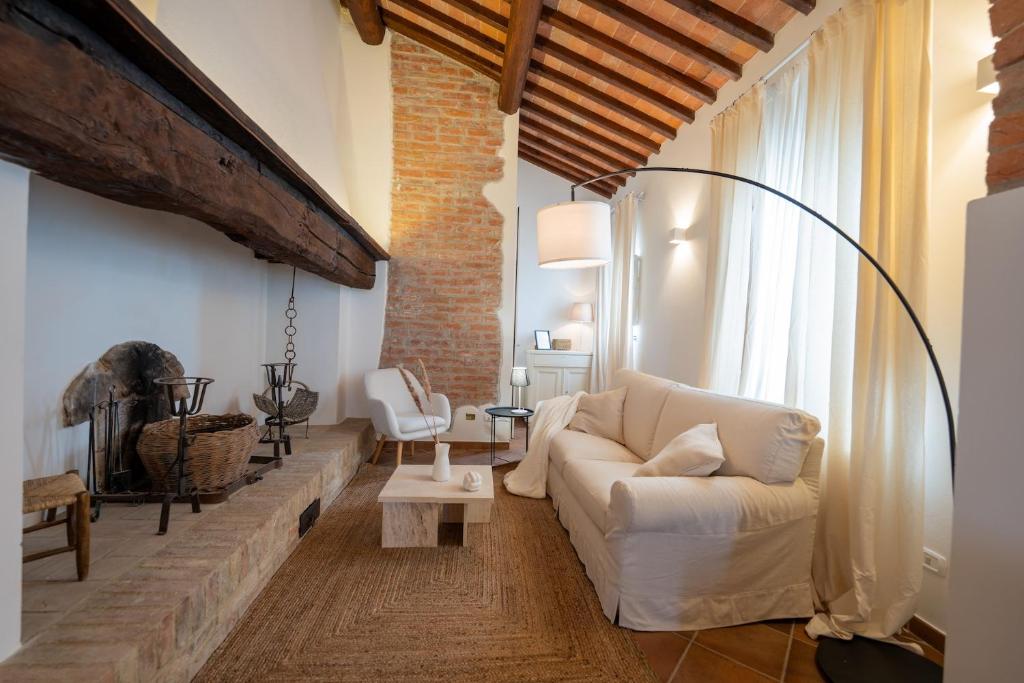 ein Wohnzimmer mit einem weißen Sofa und einer Ziegelwand in der Unterkunft Agriturismo Antica Corte in Valiano
