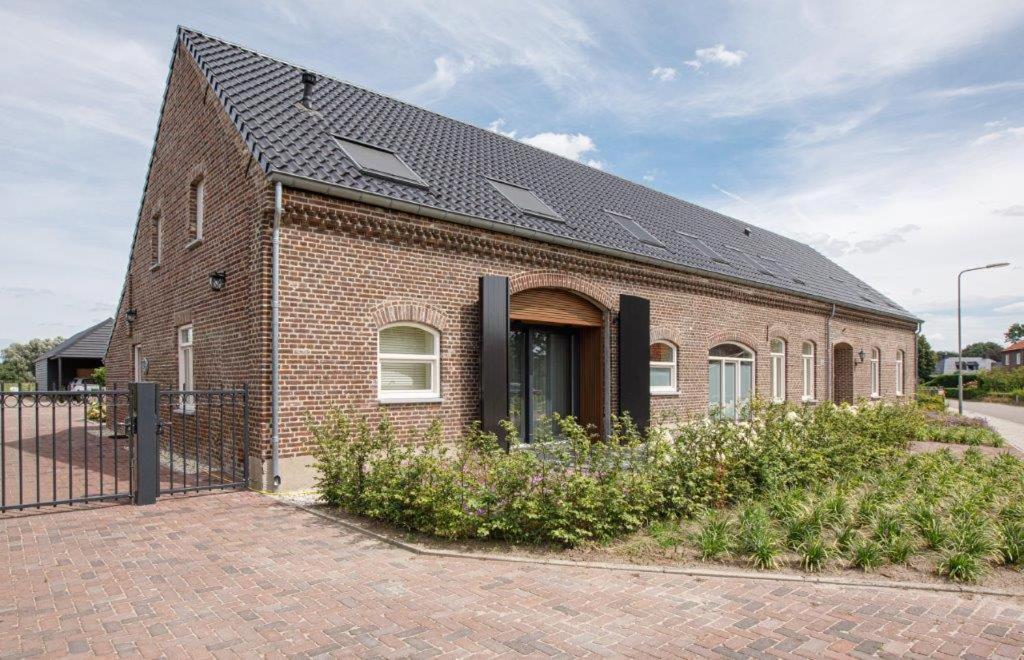 a brick house with a solar roof at Barn24 - The Stable & The Loft in Roggel
