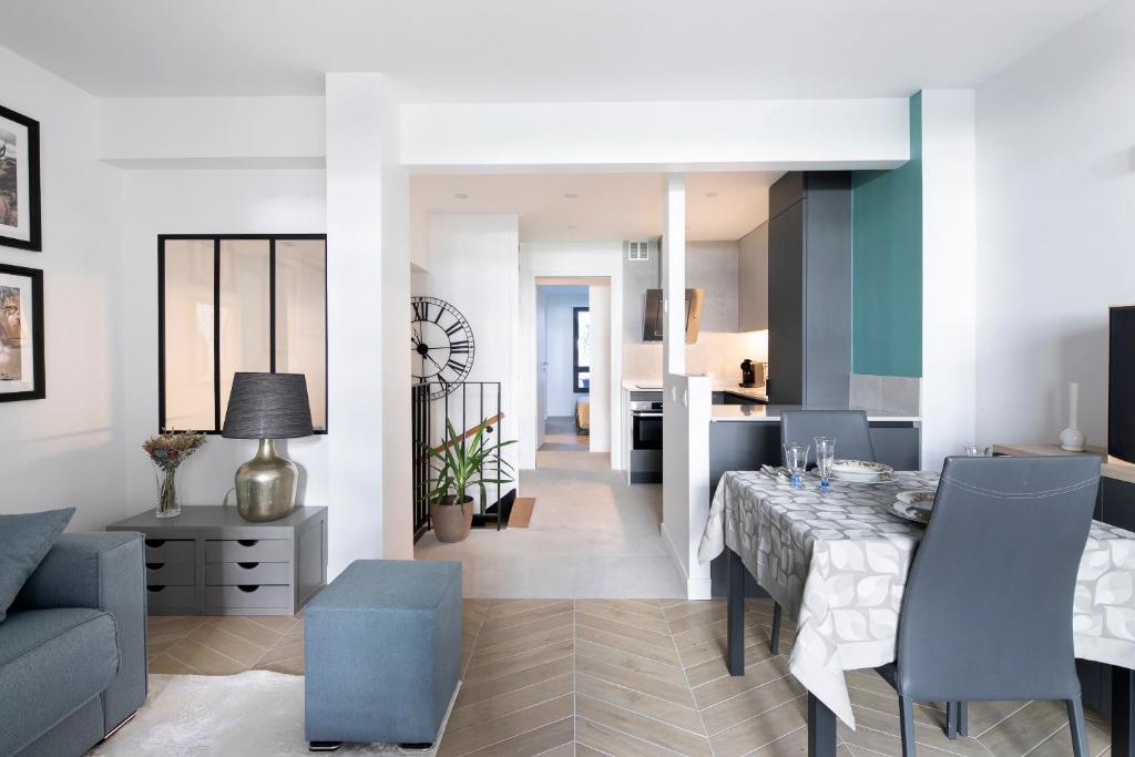 ein Esszimmer und ein Wohnzimmer mit einem Tisch und Stühlen in der Unterkunft Loft 52m²+parking à 15 min de Paris centre in Les Lilas