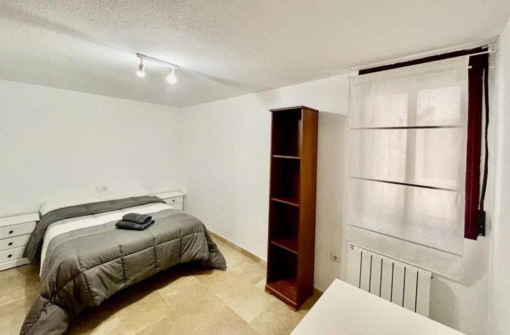 a white bedroom with a bed and a window at Apartamento, piscina y parking Granada Tico Medina in Granada