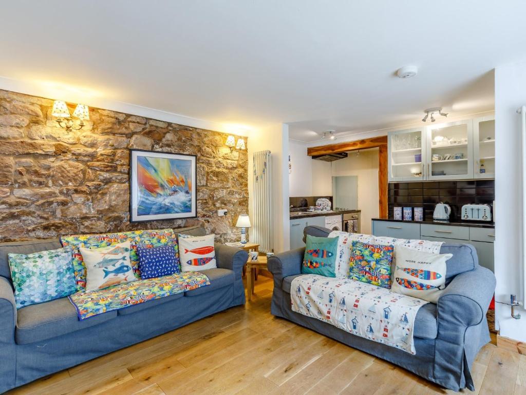 a living room with two couches and a stone wall at 2 Bed in Seahouses CN116 in Seahouses