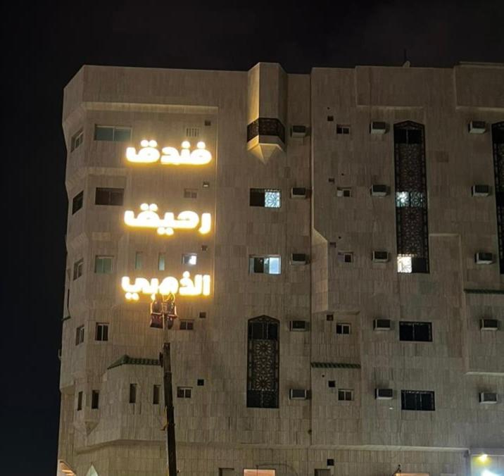 un edificio con una luz de la calle delante de él en فندق رحيق الذهبي en Medina