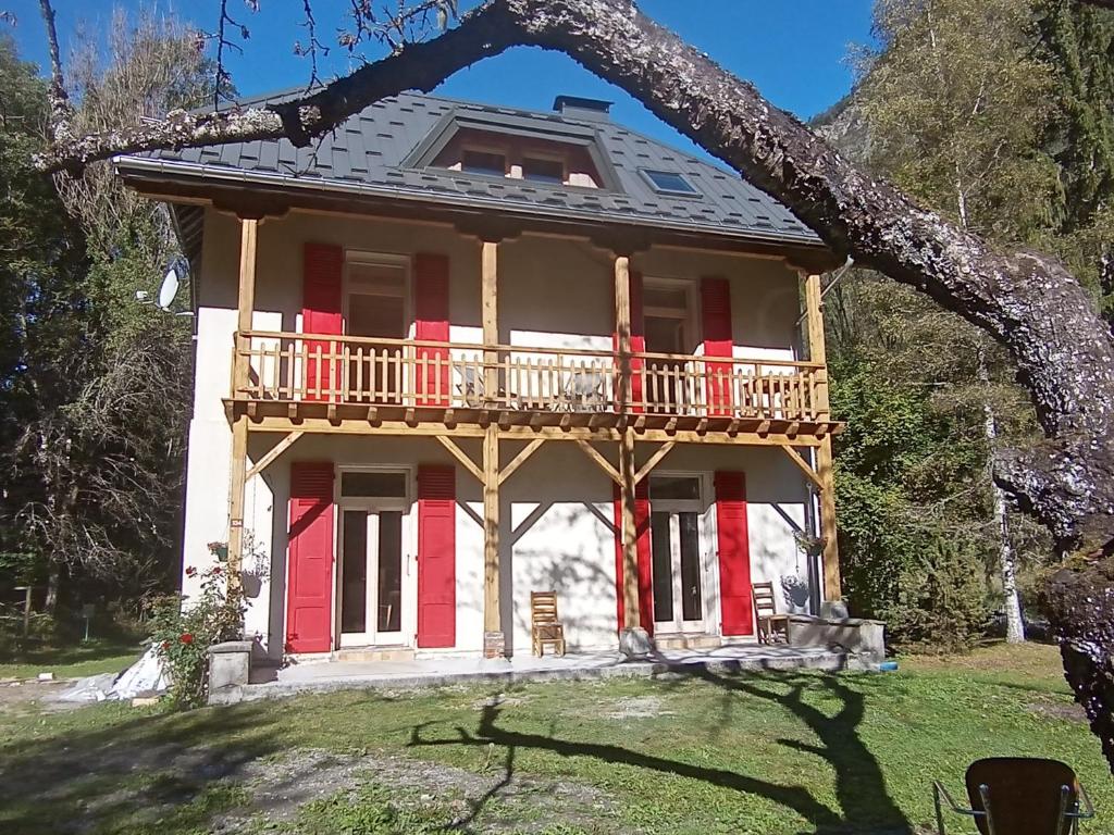 dom z czerwonymi drzwiami i balkonem w obiekcie la grande ourse w mieście Planay