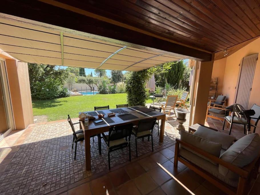 un patio avec une table, des chaises et un canapé dans l'établissement Belle Maison en Provence, à Sérignan-du-Comtat