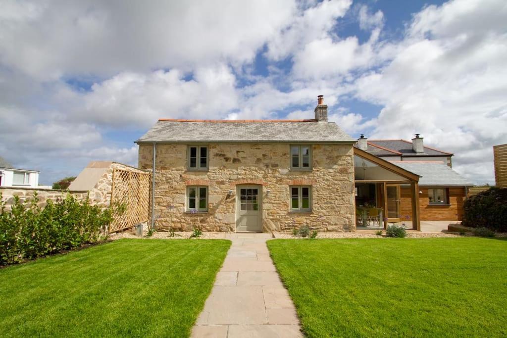 an old stone house with a green lawn at Barnwell Cottage *Stunning Cornish Cottage* Oozing Charm + Comfort in Cubert