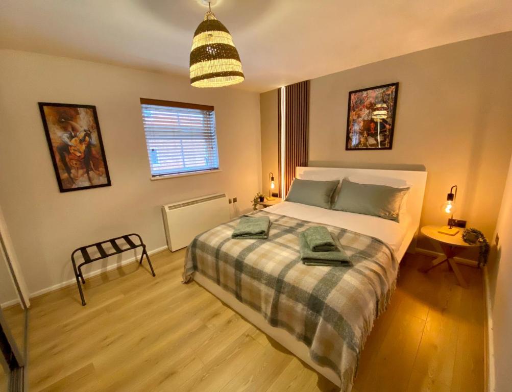 um quarto com uma cama e uma luz pendente em Central Crewe - Modern 1BR Haven em Crewe