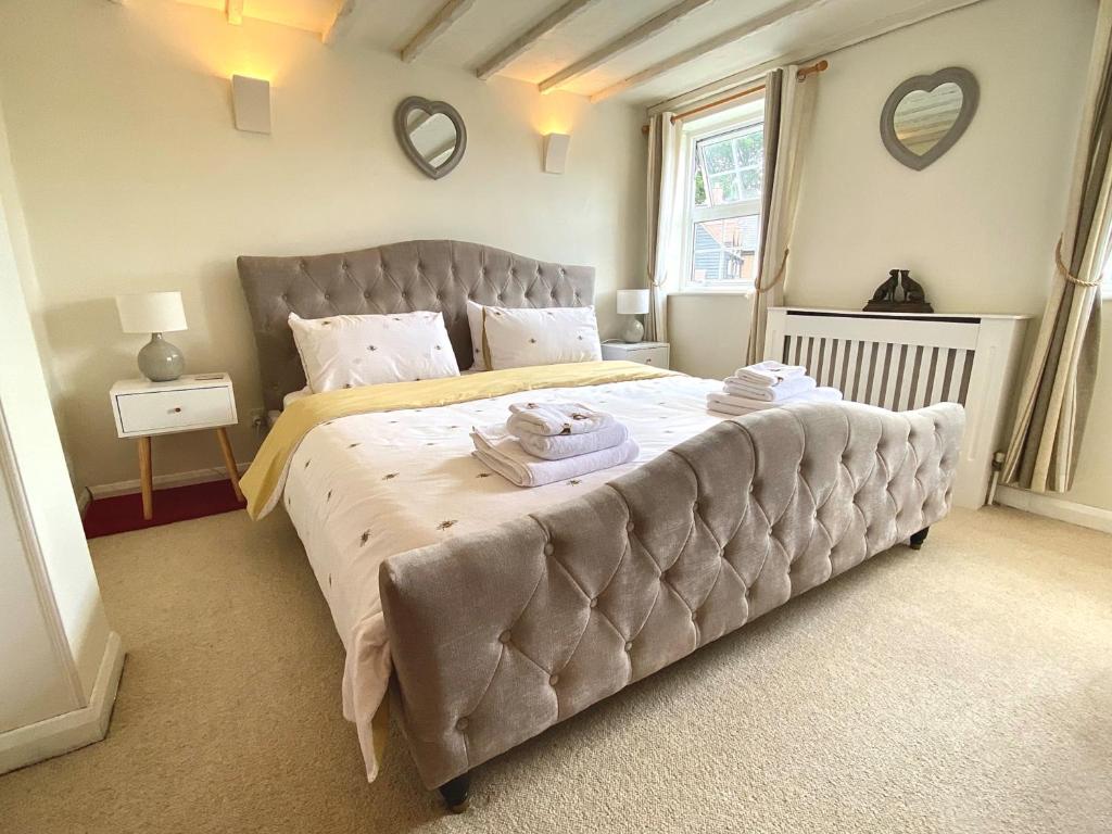 a bedroom with a large bed with two towels on it at Bumblebee Cottage - Cosy Cottage in Area of Outstanding Natural Beauty in Hemel Hempstead