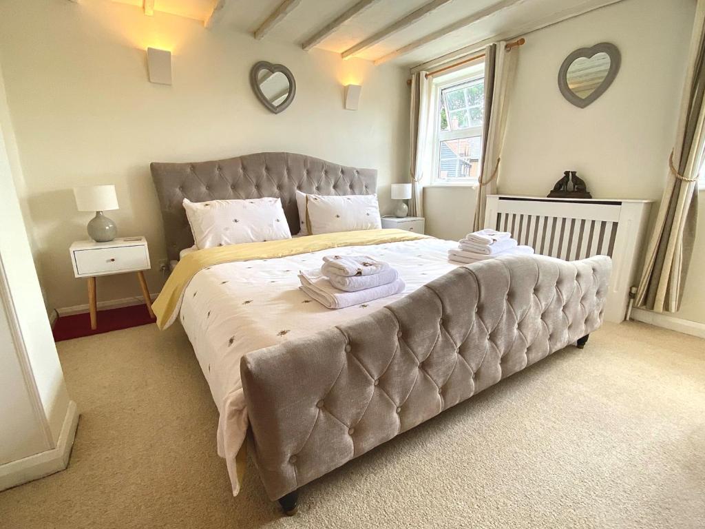 une chambre avec un grand lit avec deux serviettes dessus dans l'établissement Bumblebee Cottage - Cosy Cottage in Area of Outstanding Natural Beauty, à Hemel Hempstead