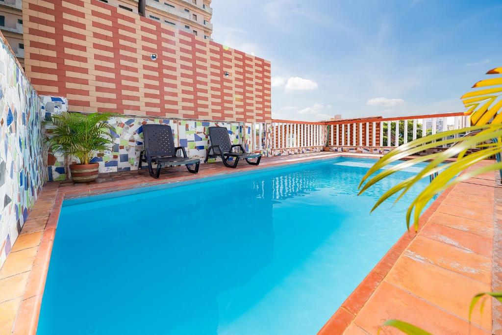 a pool at a hotel with two chairs next to it at Villa Santos Apartaestudios in Barranquilla