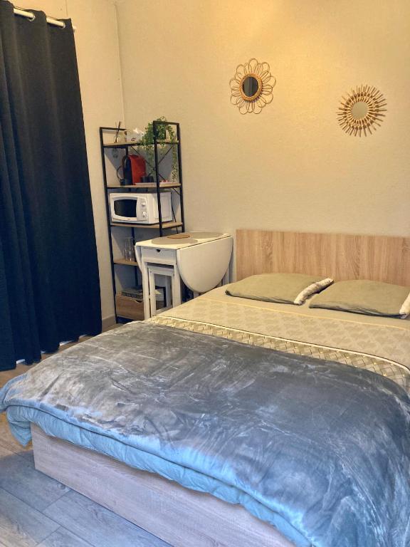 - une chambre avec 2 lits, une table et une étagère dans l'établissement Appartement calme et bien situé, à Tarbes