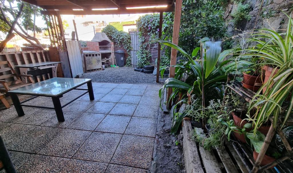 un patio con una mesa y un montón de plantas en Casa 2h 2b con patio y quincho en Valparaíso