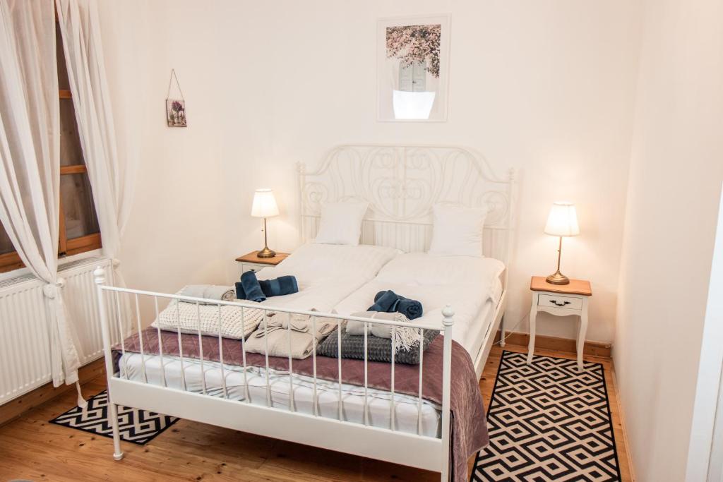 1 cama blanca en una habitación con 2 lámparas en VB36 Vendégház en Villány