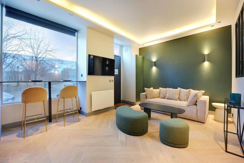 un salon avec un canapé, une table et des chaises dans l'établissement Appartement Chic - 1BR 4P - Tour Eiffel Invalides, à Paris