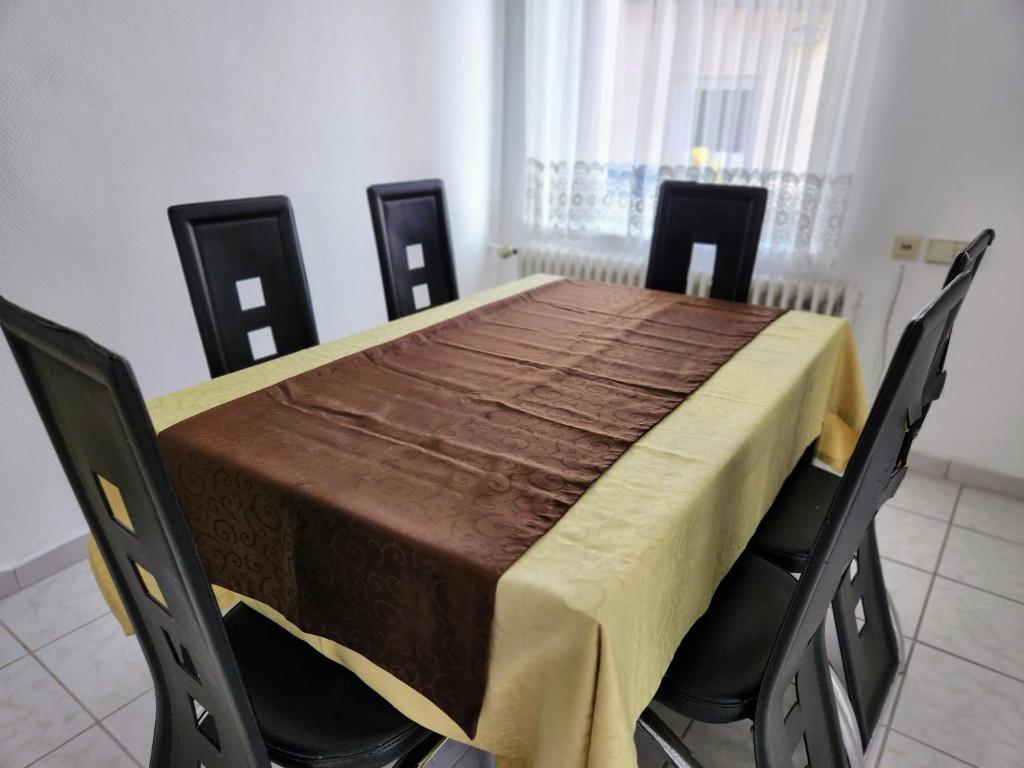 einen Esstisch mit einem gelben Tischtuch darauf in der Unterkunft Dhh for fitters and craftsmen in Baden-Baden