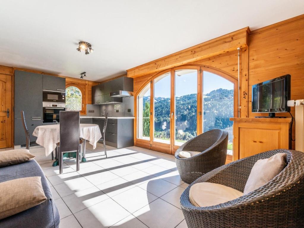 une cuisine et un salon avec une table et des chaises dans l'établissement Charmant appartement: 1 ch, parking, WiFi, animaux admis - FR-1-671-13, aux Gets