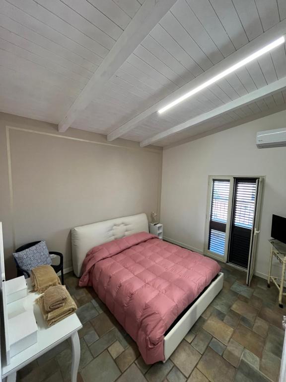Schlafzimmer mit einem Bett mit einer roten Bettdecke in der Unterkunft XXXI MAGGIO in Catania