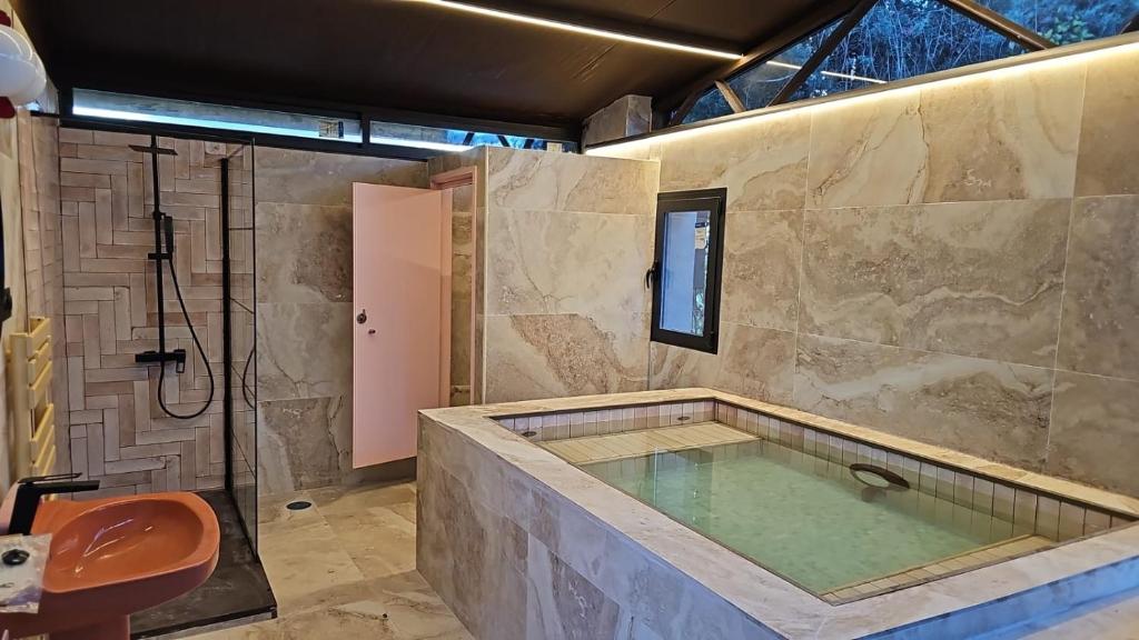 y baño con bañera grande con ducha. en HEARTS & PONIES Apartamentos con piscinas privadas cerca de la Warner en Chinchón