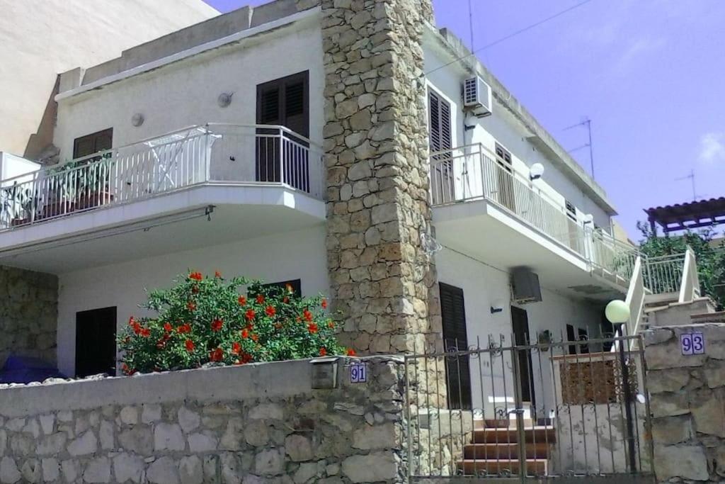 Splendido appartamento a Lampedusa, con terrazzo ! في لامبيدوسا: بيت أبيض مع شرفة وجدار حجري