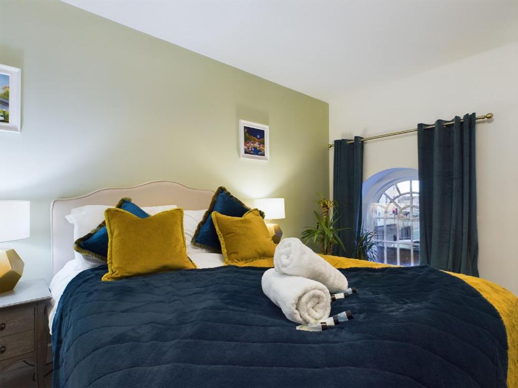 a bedroom with a large bed with yellow and blue pillows at Modern Duplex Central Free Parking Wi-Fi in Cheltenham