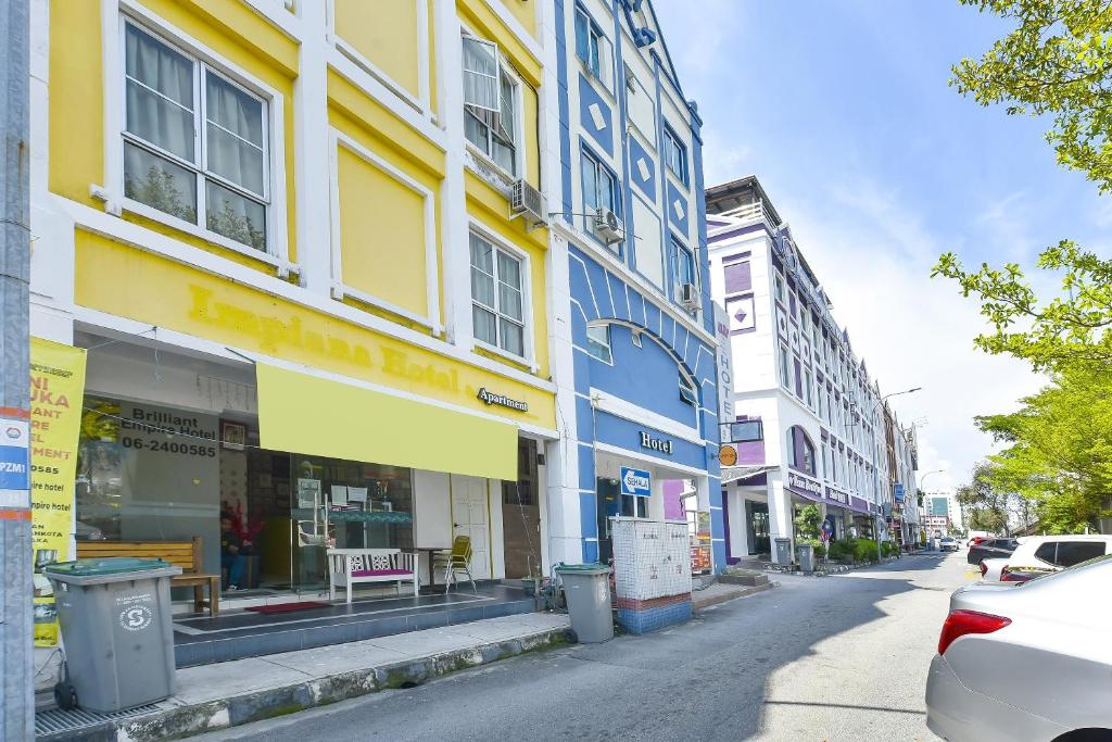 una strada cittadina con edifici e auto parcheggiati sulla strada di Brilliant Empire Hotel a Malacca