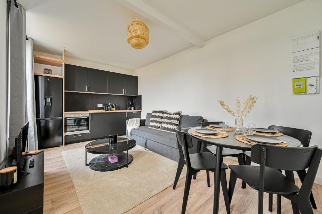 une cuisine et un salon avec une table et un canapé dans l'établissement Ptit Villemomble - Wifi - Paris & Disney, à Villemomble