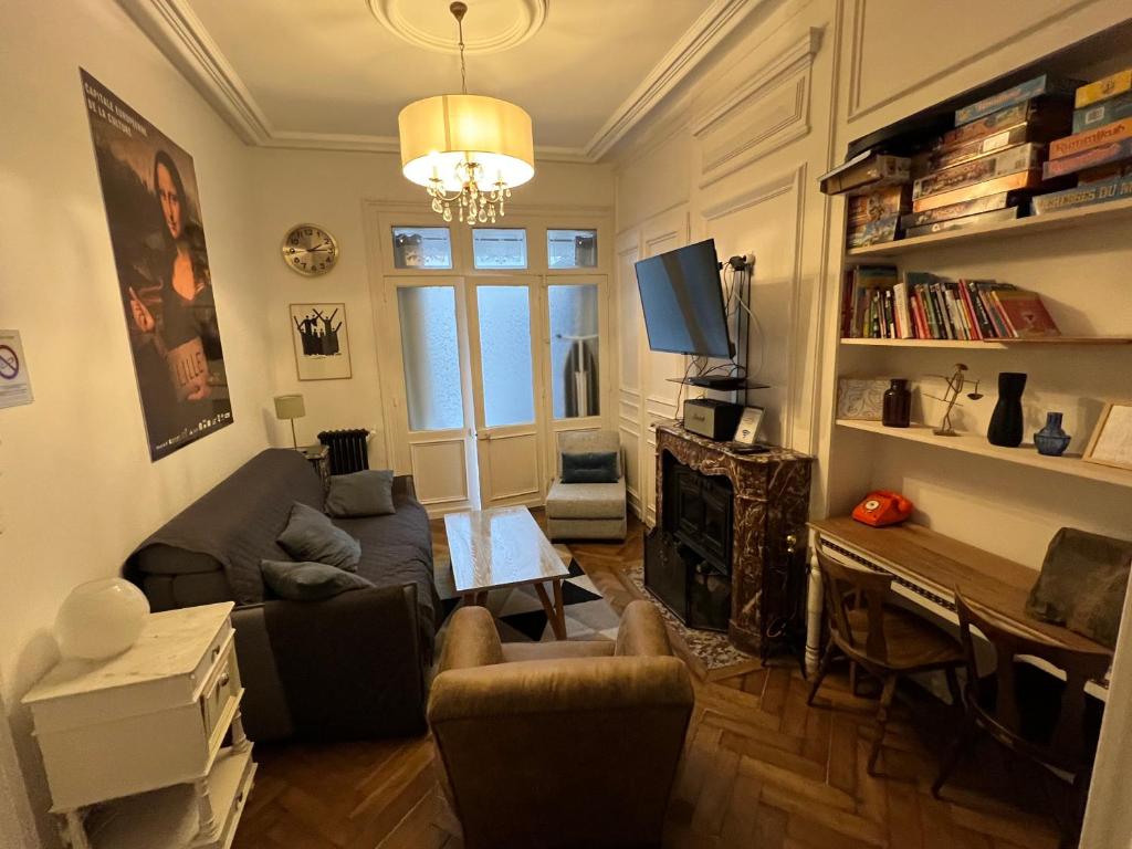 - un salon avec un canapé et une télévision dans l'établissement La petite place de la Porte d'Arras, à Lille