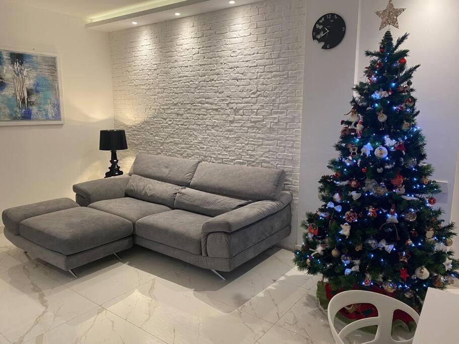 uma sala de estar com uma árvore de Natal e um sofá em Appartamento Luxury White em Viareggio