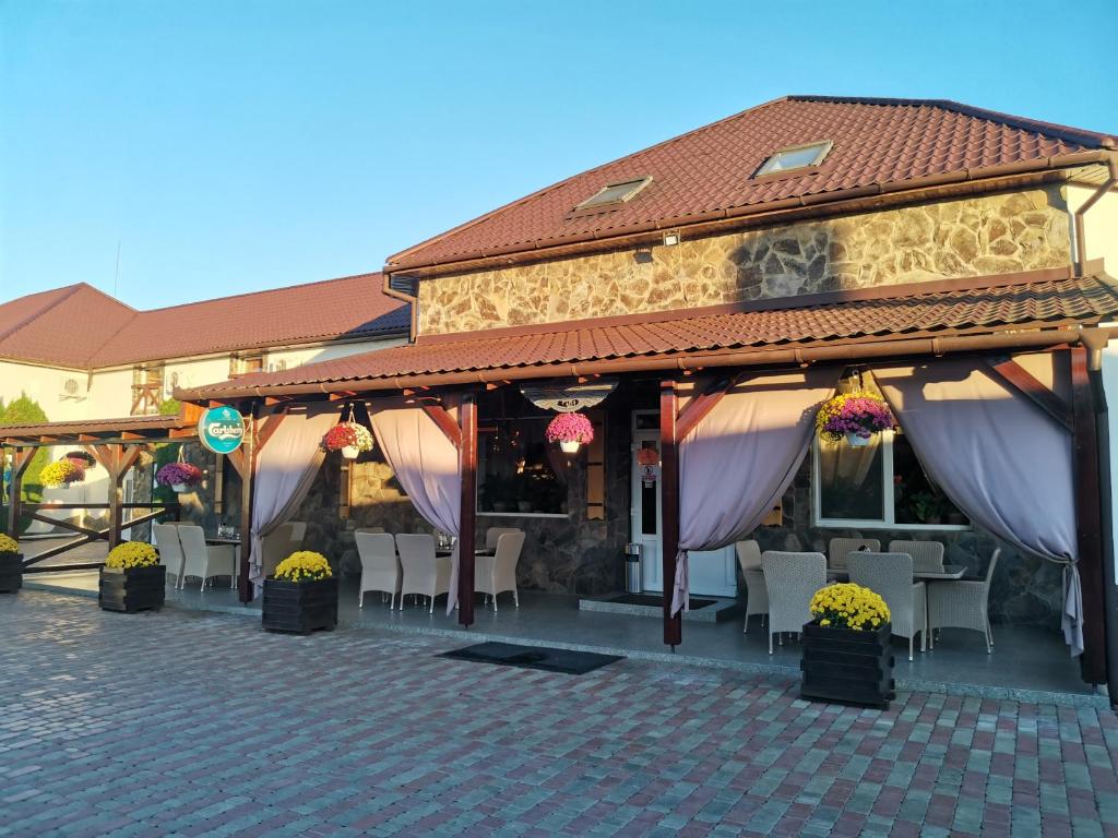 ein Restaurant mit lila Vorhängen, Tischen und Stühlen in der Unterkunft Three Aces in Velikaya Dobronʼ