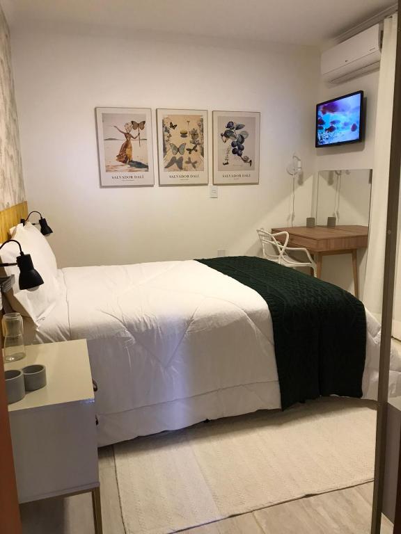 a bedroom with a bed and a tv on a wall at Sinta-se em casa. in Barbacena