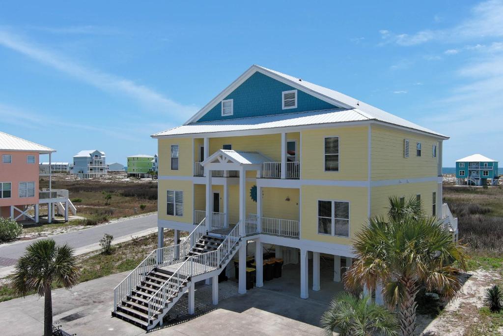 a yellow house with a green roof at The Clubhouse - Fort Morgan in Gulf Shores
