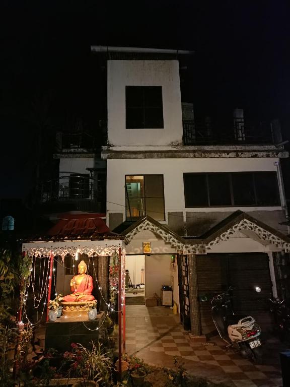 una statua di Buddha di fronte a una casa di notte di Buddha Kuthir a Dām Dim