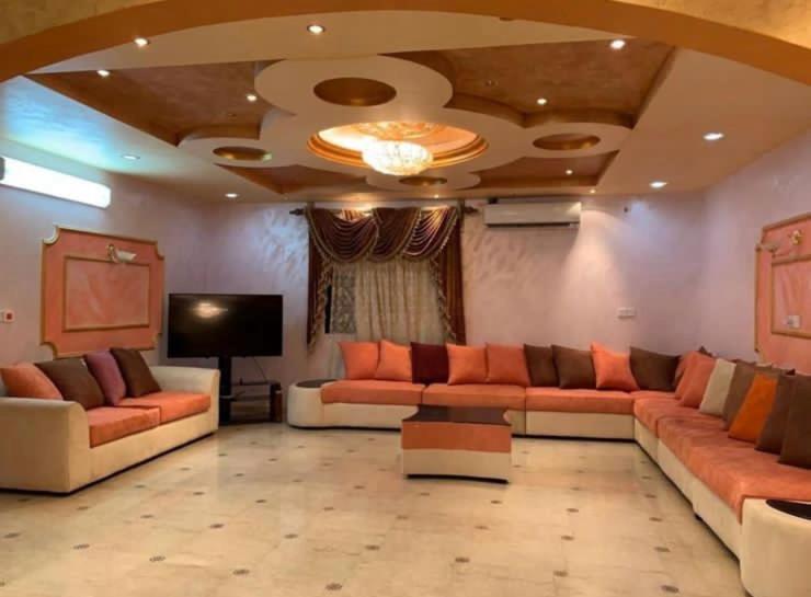 a living room with couches and a flat screen tv at فيلا بالعلا in AlUla