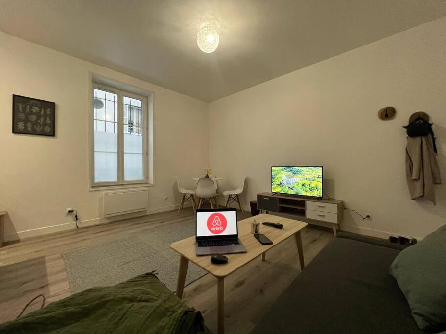 - un salon avec un ordinateur portable sur une table basse dans l'établissement Havre de Paix - Melun, à Melun