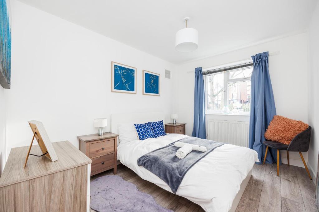 a bedroom with a bed and a dresser and a window at 3 Bedroom Flat Near Old Street in London