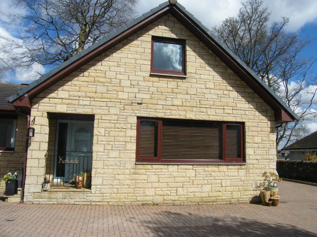 uma casa de tijolos com uma janela e uma porta em Kirkside em Auchterarder